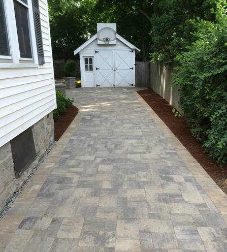 Paver driveway along side the house leading to the garage. 