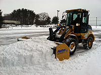 A Snow Plow removing snow from road.